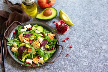 Salad with grilled chicken, avocado, brie cheese, arugula and pomegranate with vinaigrette dressing. Copy space.