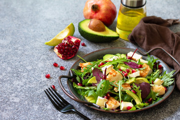 Salad with grilled chicken, avocado, brie cheese, arugula and pomegranate with vinaigrette dressing. Copy space.
