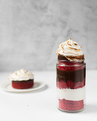 Red velvet cake in a jar with a chocolate and meringue filling and a toasted meringue topping