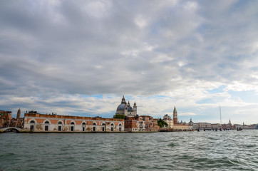 Obraz premium Looking back into Venice along the coastline from a water taxi boat in the cloudy sky