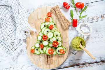 Vegetable salad with tomatoes, cucumber and olives. Christmas tree shape.