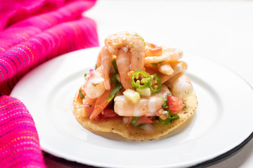 Mexican shrimp ceviche toast also called tostada on white background