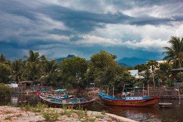 Naklejka na ściany i meble Fishing boats on the background of a Vietnamese village
