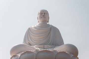 Fototapeta premium Buddha statue sitting in a lotus against the sky