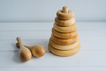 Children's pyramid and maracas are made of natural wood. Toys for children, made by hand from natural wood. Wooden shavings.