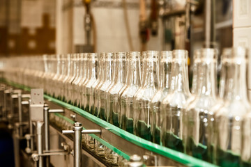 Factory for the production of alcoholic beverages. On the conveyor, vodka is bottled.