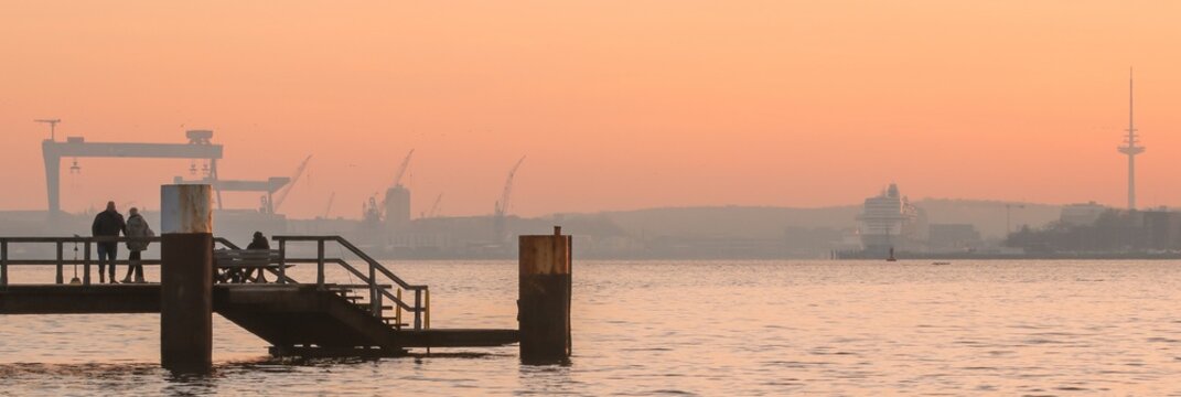 strollers on the seabridge in Kitzeberg with the skyline of Kiel