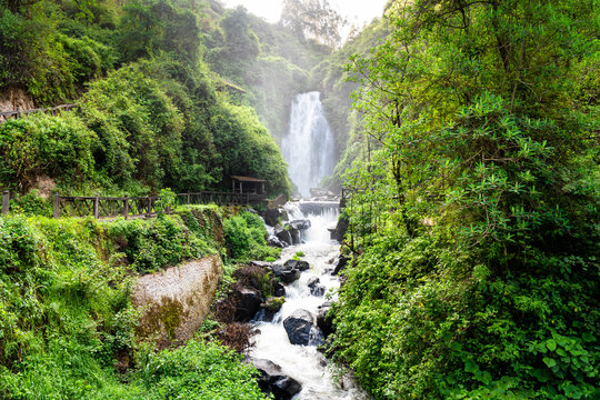 View of Peguche Waterfall in the mountains of Ecuador. It's surrounded by green forest full of vegetation