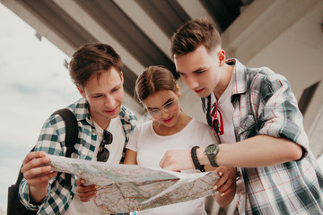 Friends Tourists Look At The Map Route Of Travel Around The City