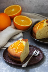 Orange cake with slices of orange on a concrete background.