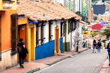 BOGOTA, COLOMBIA - NOV 10, 2019: View of a charming lively colorful street in La Candelaria district in old part of Bogota, Colombia, South America. Small historical townhouses make it wonderful. © Milosz Maslanka