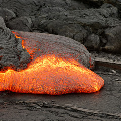 Detailed view of an active lava flow, hot magma emerges from a crack in the earth, the glowing lava appears in strong yellows and reds - Hawaii, Big Island, Kilauea volcano, Puna district, Kalapana