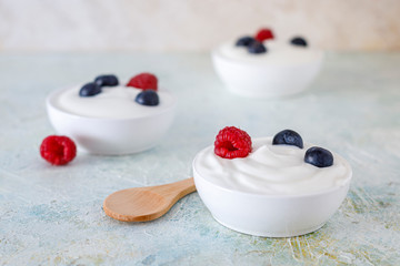 Obraz na płótnie Canvas Yogurt with raspberry and blueberries on a green table