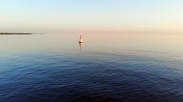 AERIAL: Super beautiful sunset over the ocean with calm waters. sea buoy. Umag, Croatia