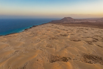 Fototapeta na wymiar High angle view of road going through Corralejo dunes nature park in Fuerteventura. Aerial drone shot in october 2019
