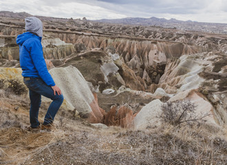 Person looks to distant dramatic moody  valley in Kapadokya. with rocky geologcal formations in the...