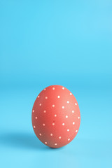 One bright red painted easter egg on blue surface. Colorful easter eggs decoration. Copy space for text.