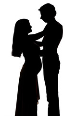 Silhouettes of two people men and a pregnant woman cuddling on a white background. The concept of warm family relationships. Copyspace