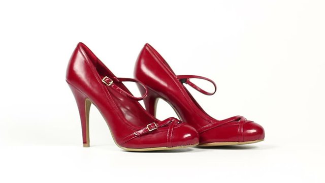 Red high heel shoes coming into Focus - Tracking shot on White Background. Stock Video Clip Footage - Side view
