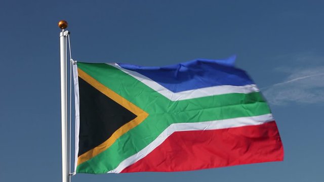 Raising the South Africa Flag flying in the wind outdoors with Blue sky behind - South African flag on flagpole. Stock Video Clip Footage