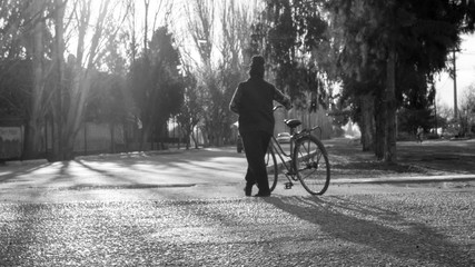 Mujer partiendo con su bicicleta por el camino rural