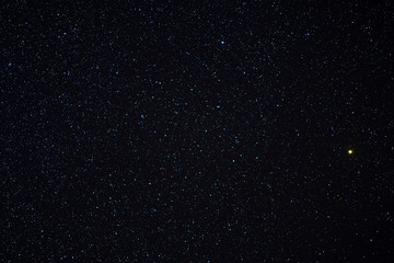 Betelgeuse glowing yellow on dark starry winter sky