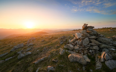 Obraz premium A bright orange sunset sky over the mountains of the Lake District from Ramspgill Head with views of the summits of The Knott and Rest Dodd below.