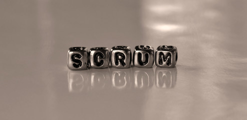 Scrum -  word from metal blocks - concept sepia tone photo on shine background
