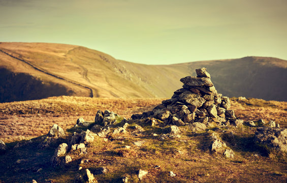 The Warm Evening Glow Over The Summit Of Rampsgill Head With High Stree Just Off To The Left In The Lake District UK.