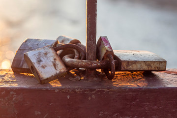 Rusty Padlocks Locked in a Bundle on Bridge Above The River