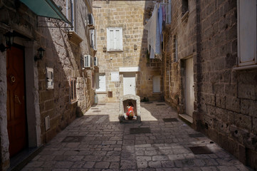 Small figure of a saint in the courtyard of houses, Old town of Taranto, Italy.