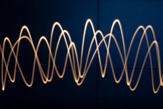 Segni luminosi a forma di onda sinusoidale ottenuti muovendo una torcia elettrica nel buio