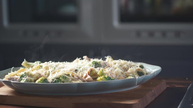 Chef sprinkles parmesan cheese spaghetti pasta on a plate in a restaurant kitchen. Food ingredient. Cooking on cuisine. Cooked for gourmet. Prepare food to eat. Gastronomy culinary. Delicious dinner.