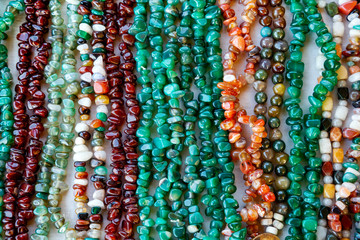 Beautiful decoration from beads of natural colored stones on market closeup