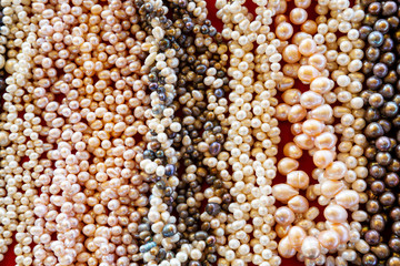 Beautiful decoration from beads of natural freshwater pearls on market closeup