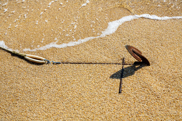 Old rusty anchor of motor boat in the sand on the beach close up