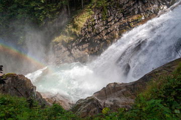 Rainbow in the water splinter of a mountain waterfall in the Austrian Alps
