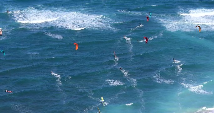 Wide view of kite surfers beach. Windsurfers riding on waves. Kite Surfing. Water-sports activity.