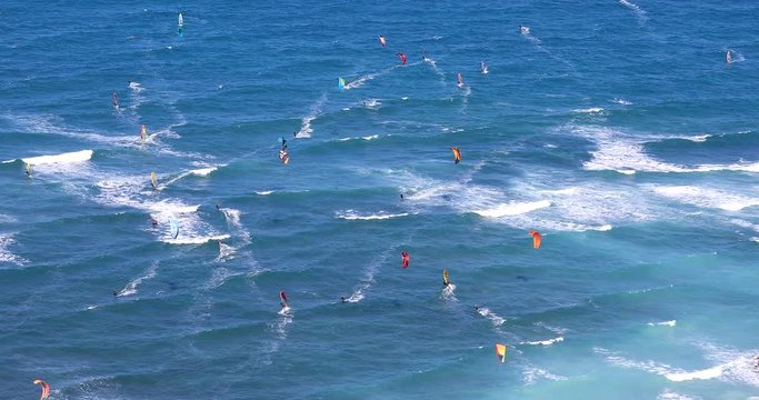 Wide view of kite surfers beach. Windsurfers riding on waves. Kite Surfing. Water-sports activity.