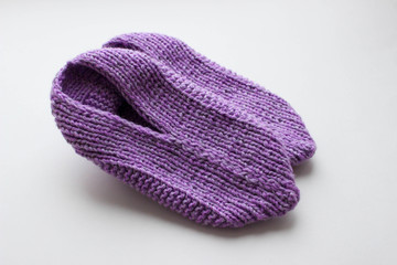 Handmade knitted pink slippers on white background