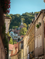 a center-european street with a mansion/castle in the background on the top of a hill