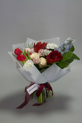 Beautiful summer bouquet in bright colors, gray backdrop, selective focus
