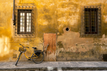 Fototapeta na wymiar Yellow bicycle chained to a door handle