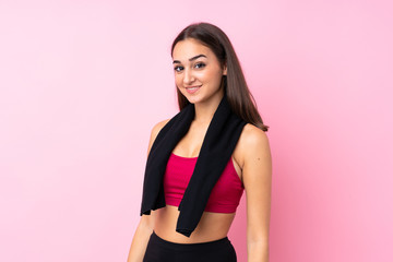 Young sport girl over isolated pink background with sport towel