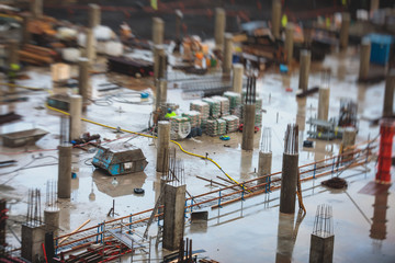 Process of apartment block construction, building site of multistoried residential house with underground car parking lot garage, with group of workers and engineers