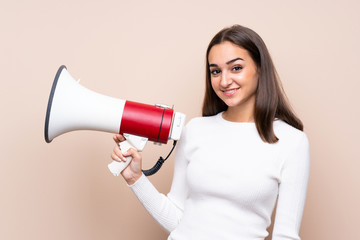Young woman over isolated background holding a megaphone