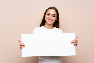 Young woman over isolated background holding an empty white placard for insert a concept