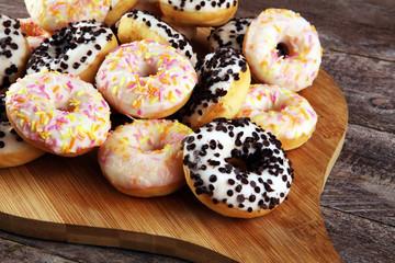 assorted donuts with chocolate frosted, pink glazed and sprinkles donuts. delicious snack