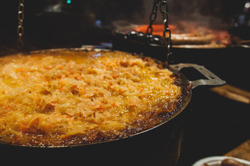 Variety assortment of different traditional european street food with sausages, mashed potatoes and stewed cabbage at one of the stalls at the Christmas market, Town Hall Square of Tallinn, Estonia