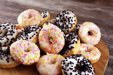 assorted donuts with chocolate frosted, pink glazed and sprinkles donuts. delicious snack